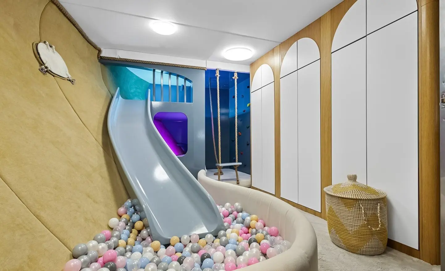 Indoor kids play area with a curved slide and colorful ball pit
