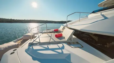 Bow deck view of By My Side yacht with seating and railings, sunlit sea