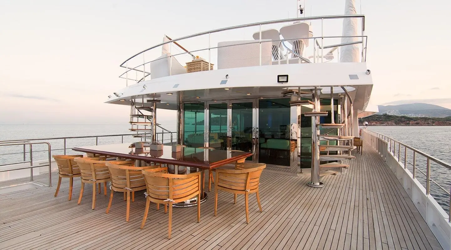 O'Natalina yacht at dock with dining table setup on deck and sunset light