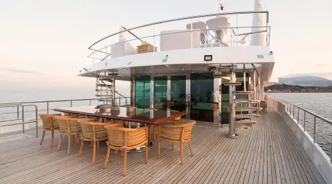 O'Natalina yacht at dock with dining table setup on deck and sunset light