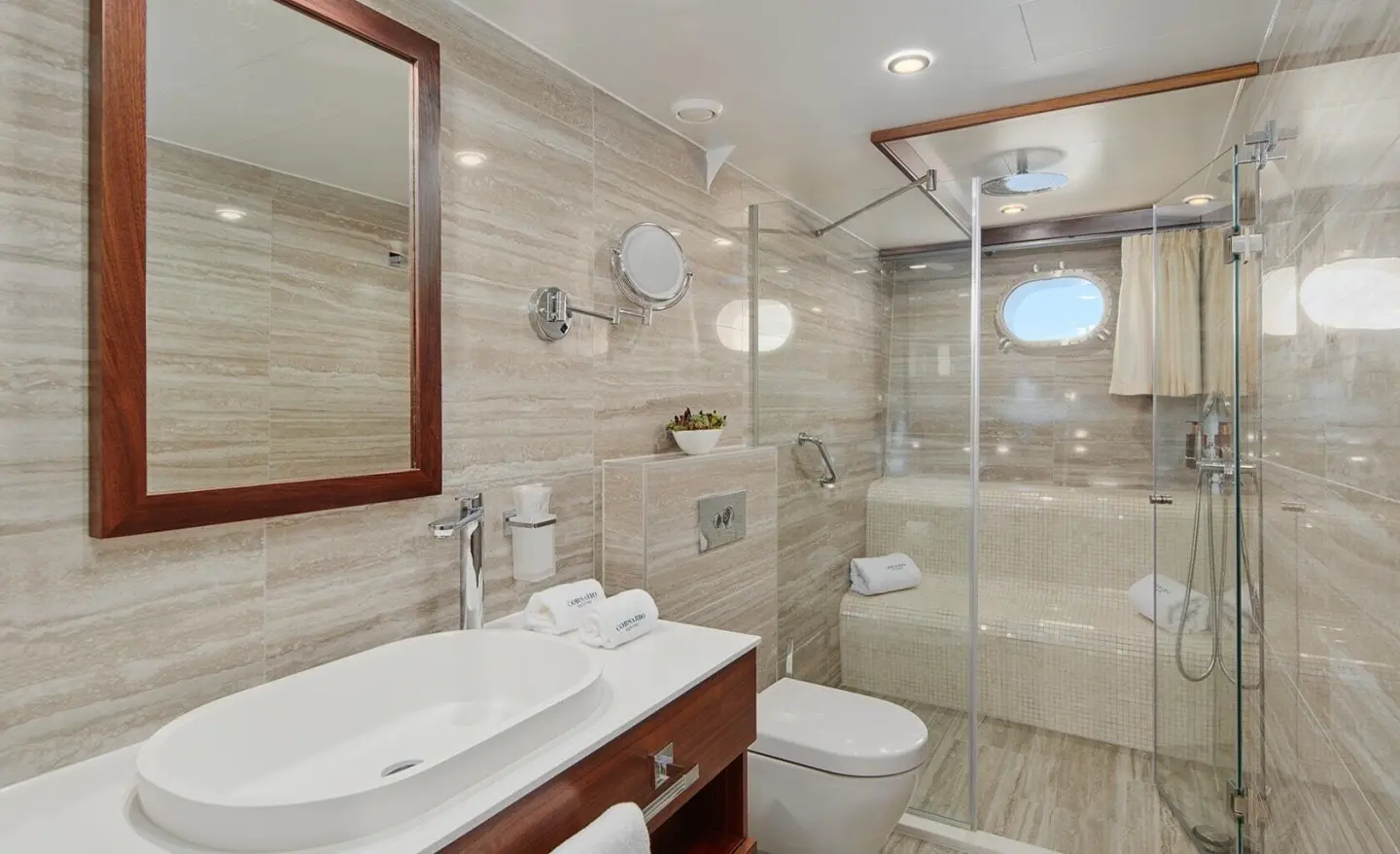 Luxurious Corsario yacht interior: marble bathroom with sink, mirror, and shower