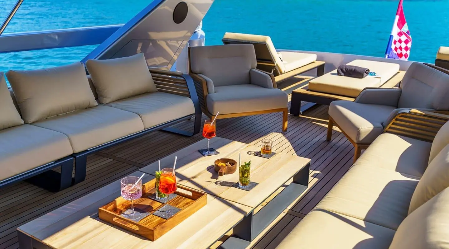 Phantom luxury yacht deck seating area with sun loungers and ocean view at sunset