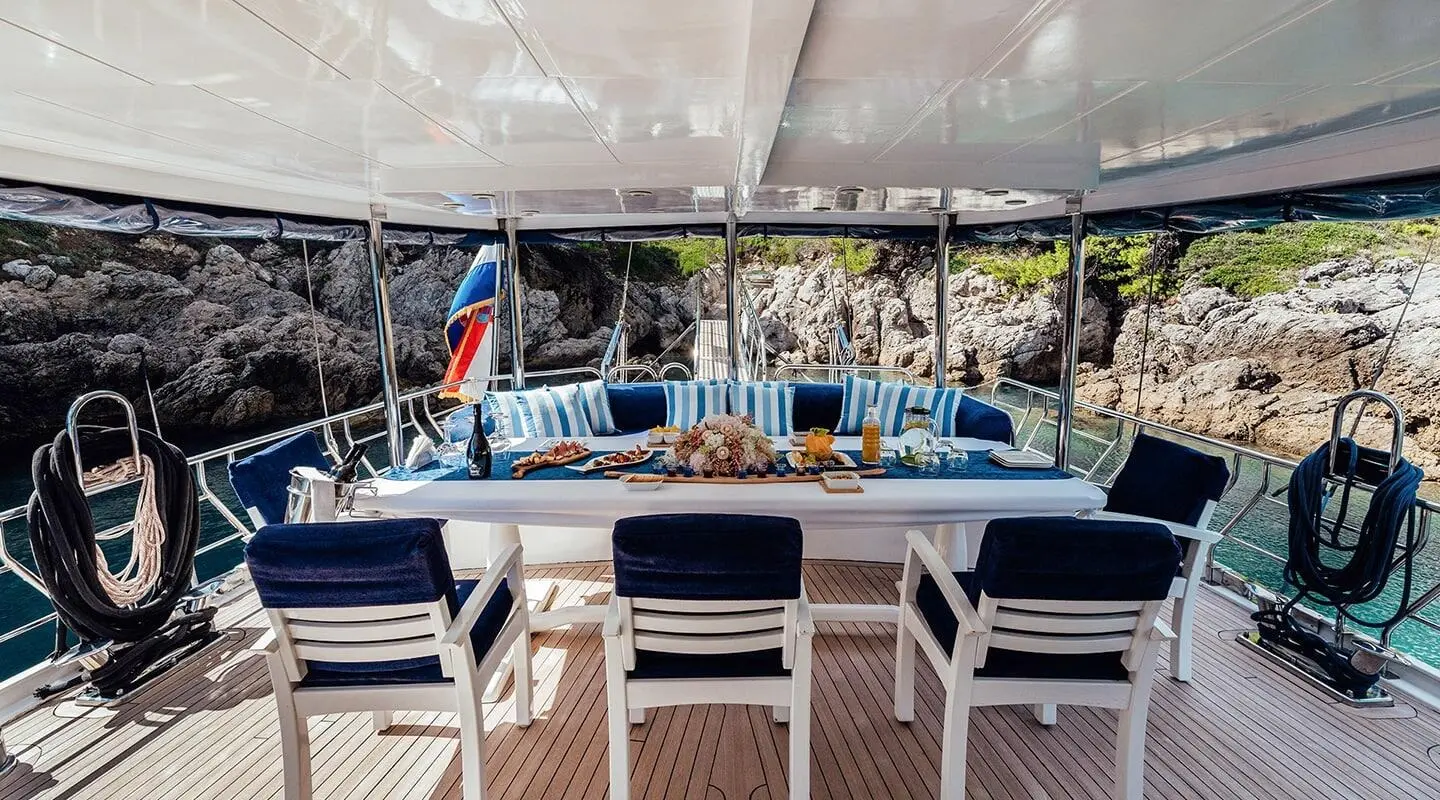 Maske yacht dining area on deck during sunset, chairs set around table