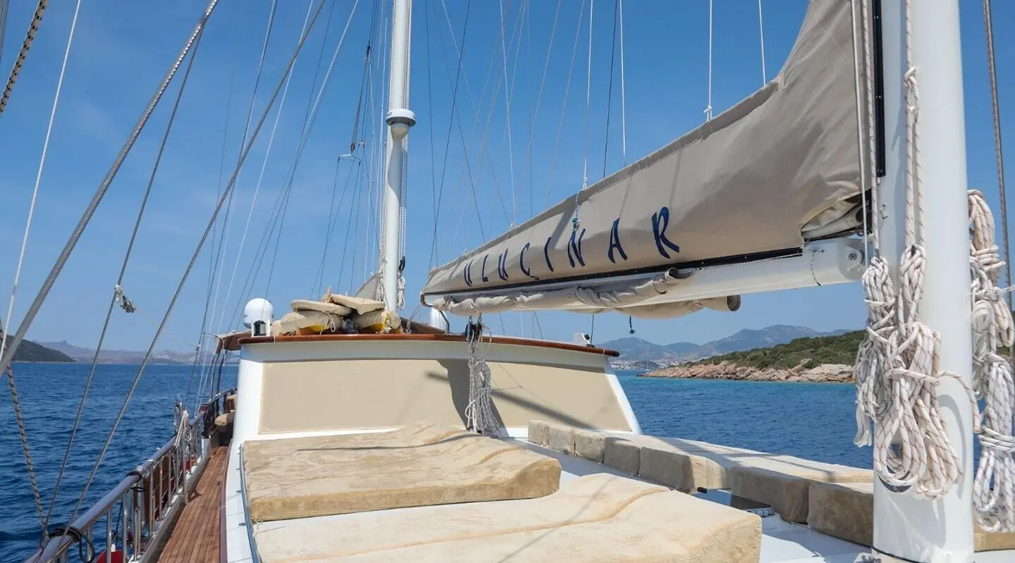 Gulet Ulucinar side deck with railing, ropes, and sail in view on calm sea