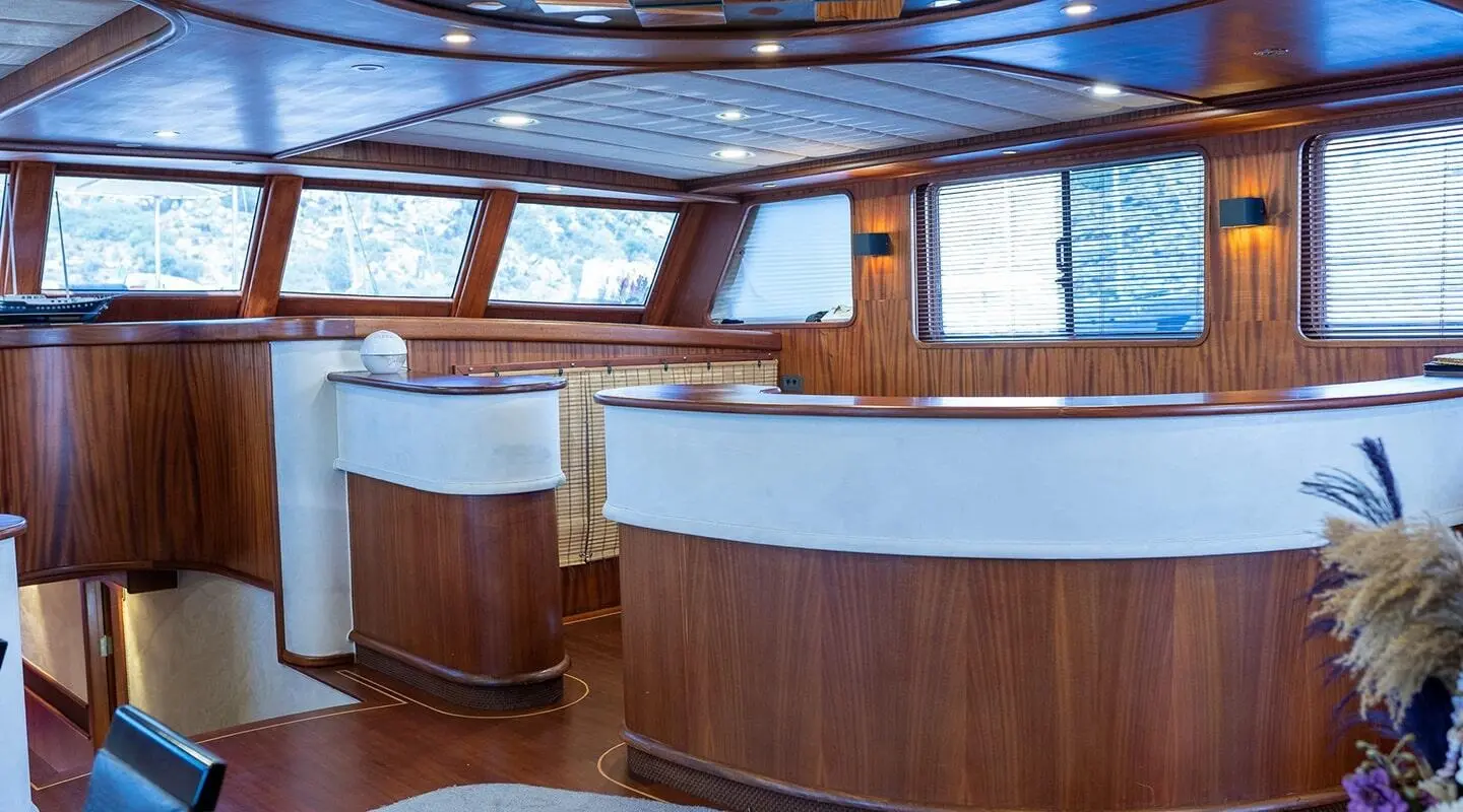 Luxurious yacht interior with wooden walls and white counter behind the bar