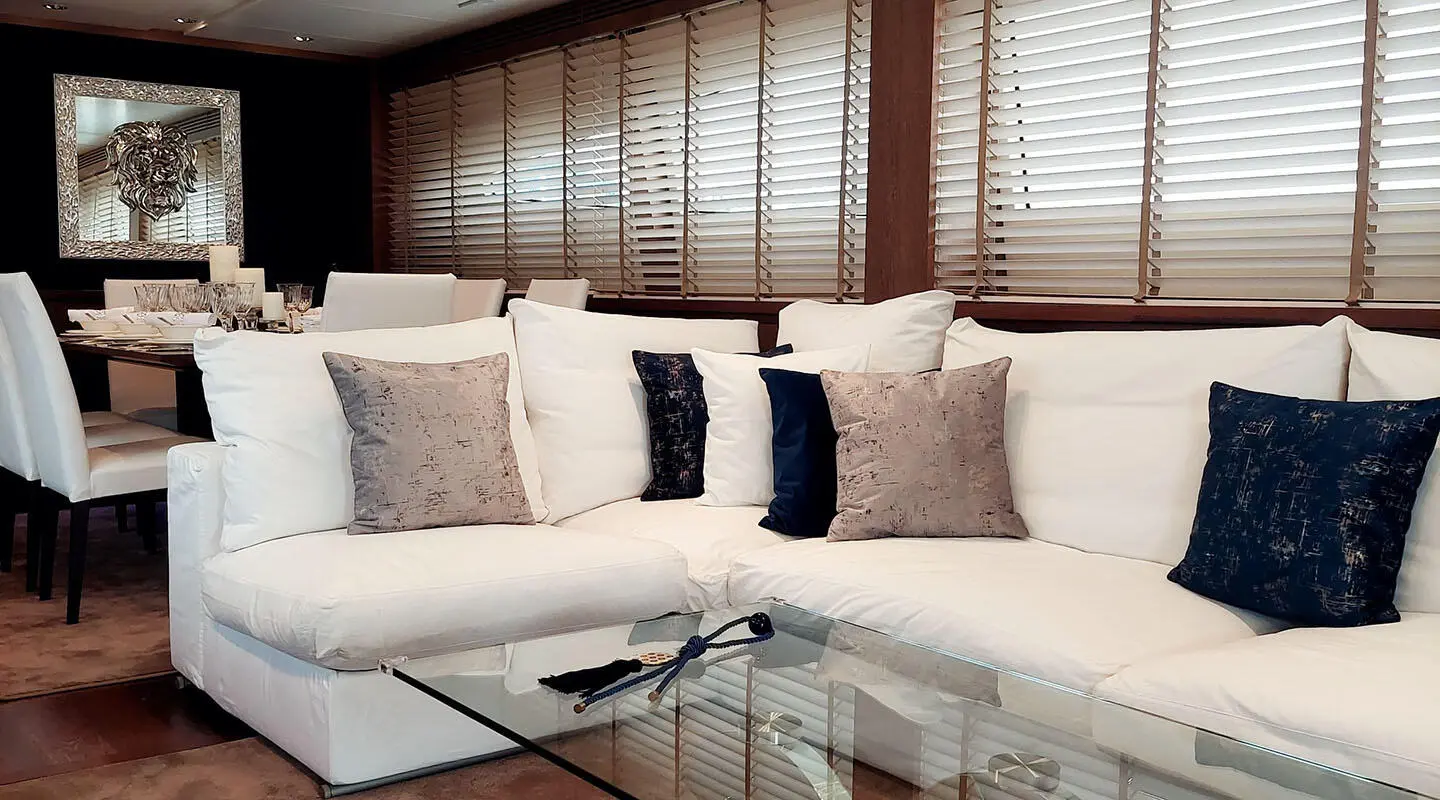 Interior scene with white sectional sofa, glass coffee table and cushions
