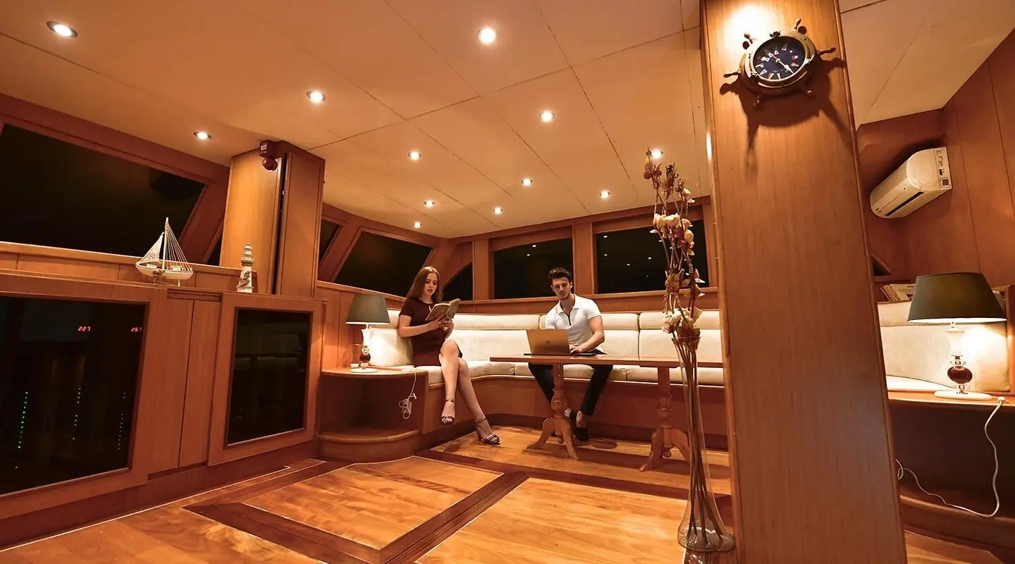 Interior shot of Blu Dream gulet saloon with warm lighting and seating