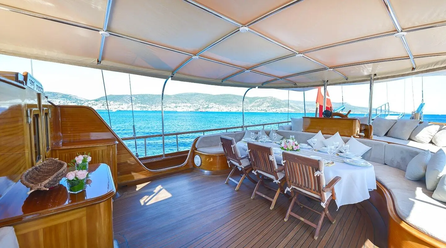 Lady Christa yacht deck with table set for sunset dining and blue ocean view