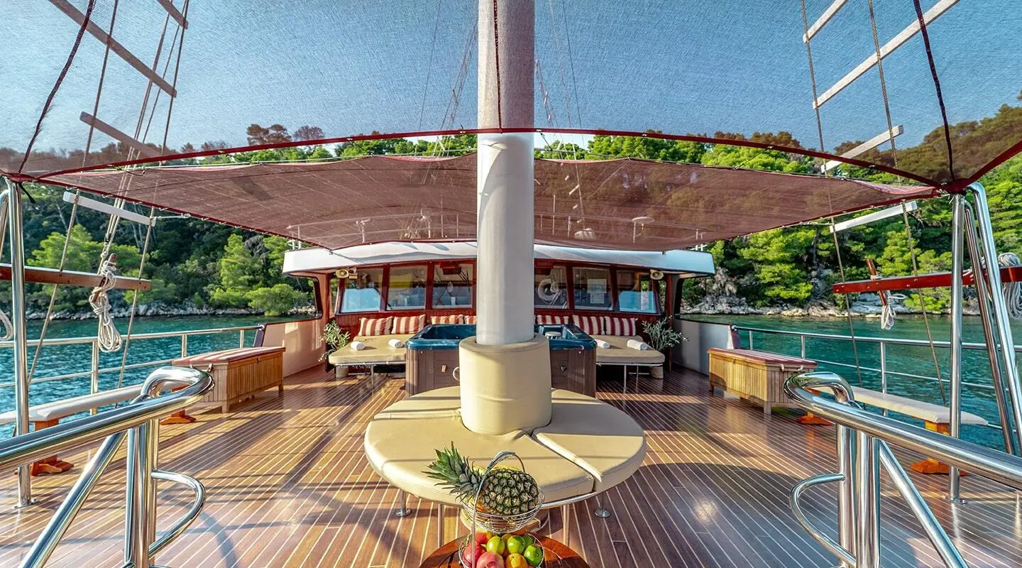 Bow deck of Cesarica gulet with aft seating and shaded area under sails