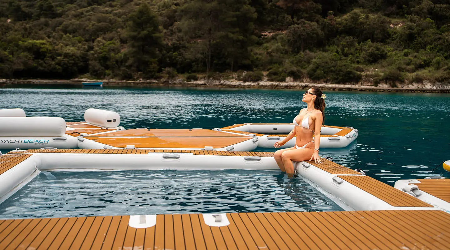 Cristal yacht with a person relaxing on a wooden deck by the water