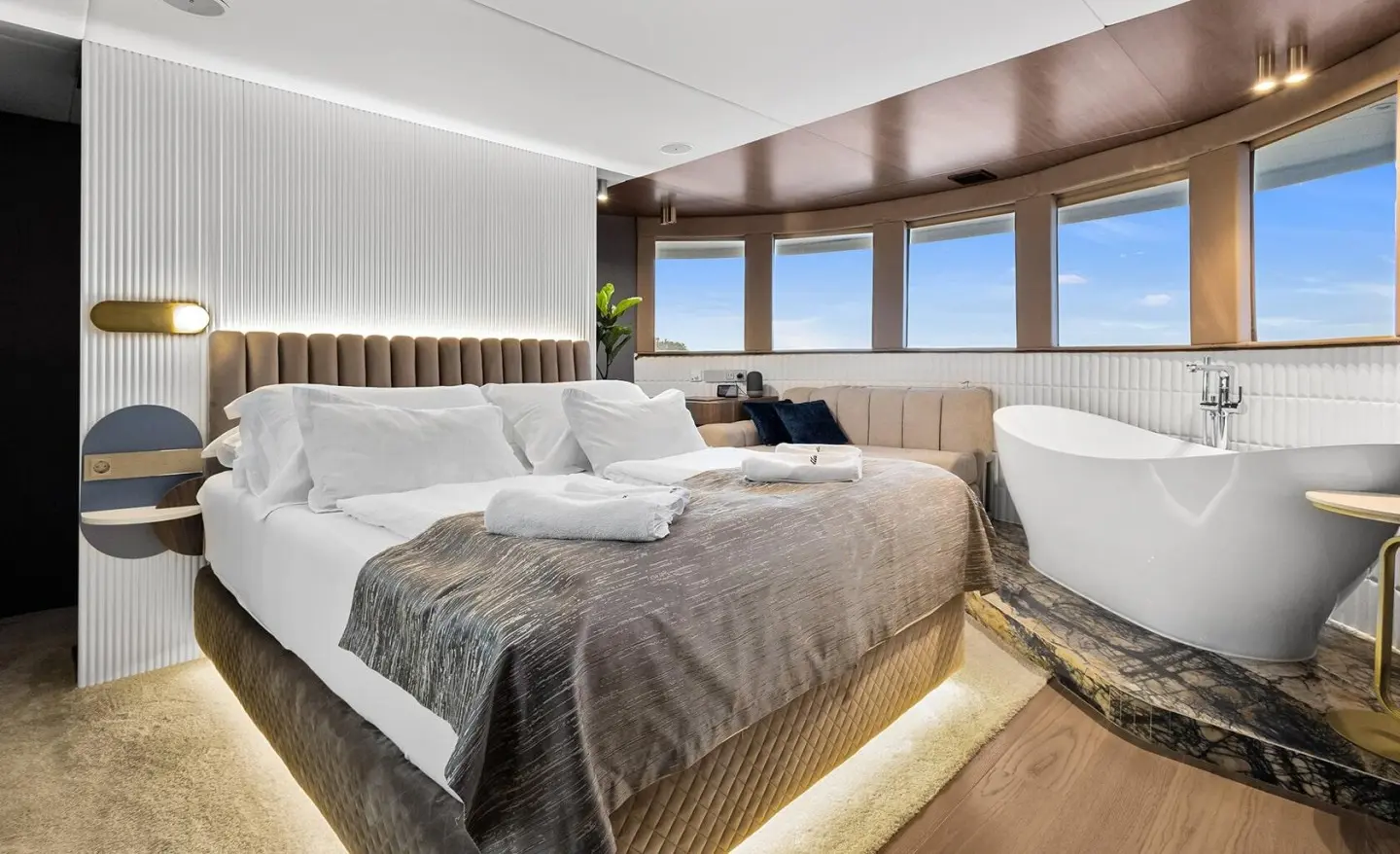 Bella yacht master cabin with large bed, white bedding, and panoramic windows