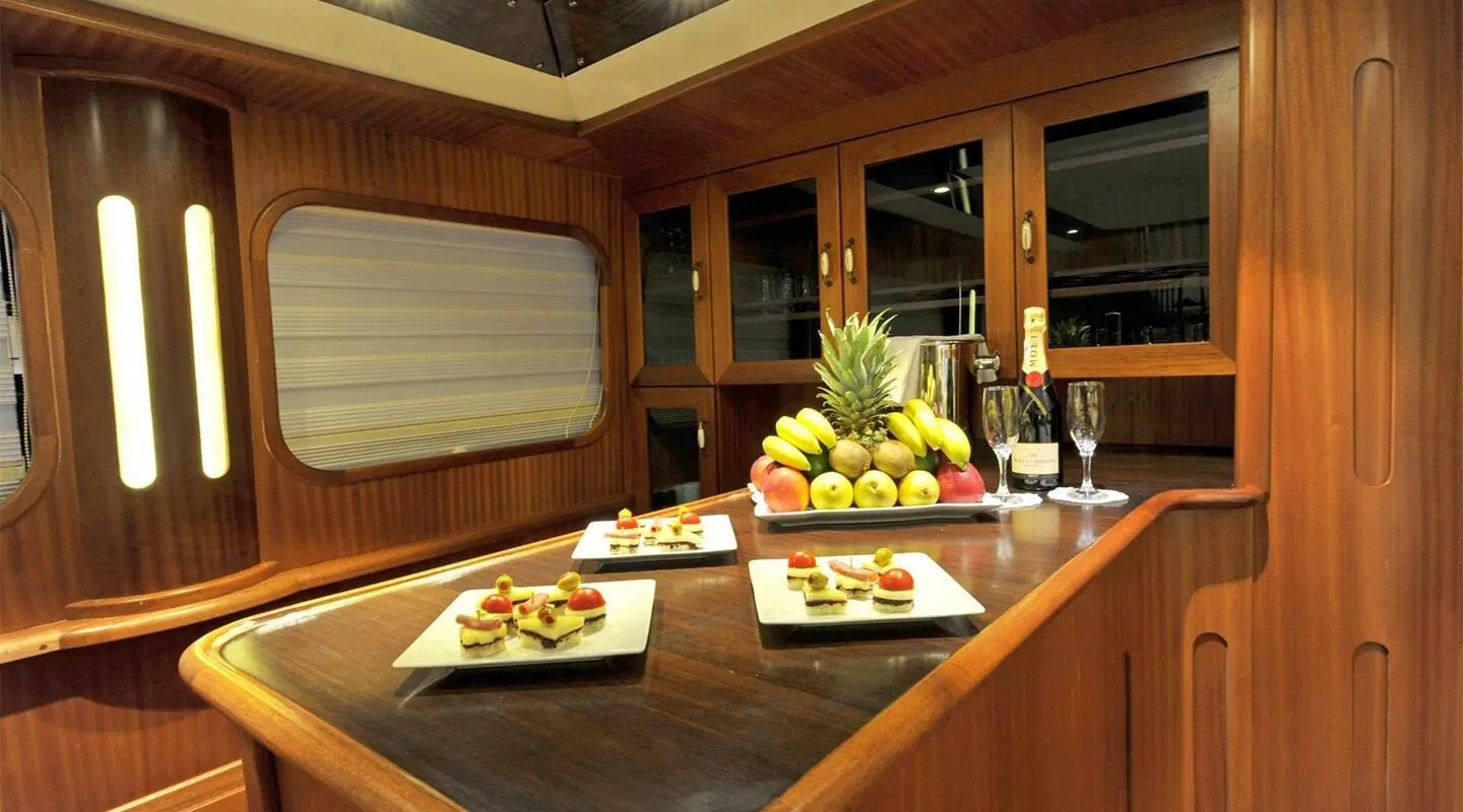 Wooden yacht bar area on deck with fruit platter and champagne