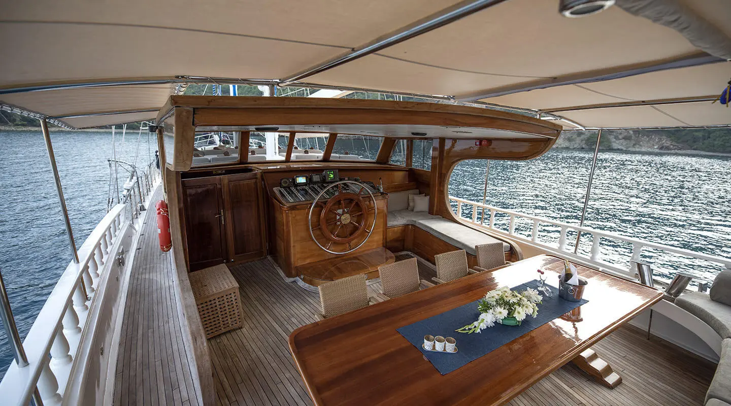 Kayhan 8 yacht charter cabin and helm on sunlit wooden deck at sea