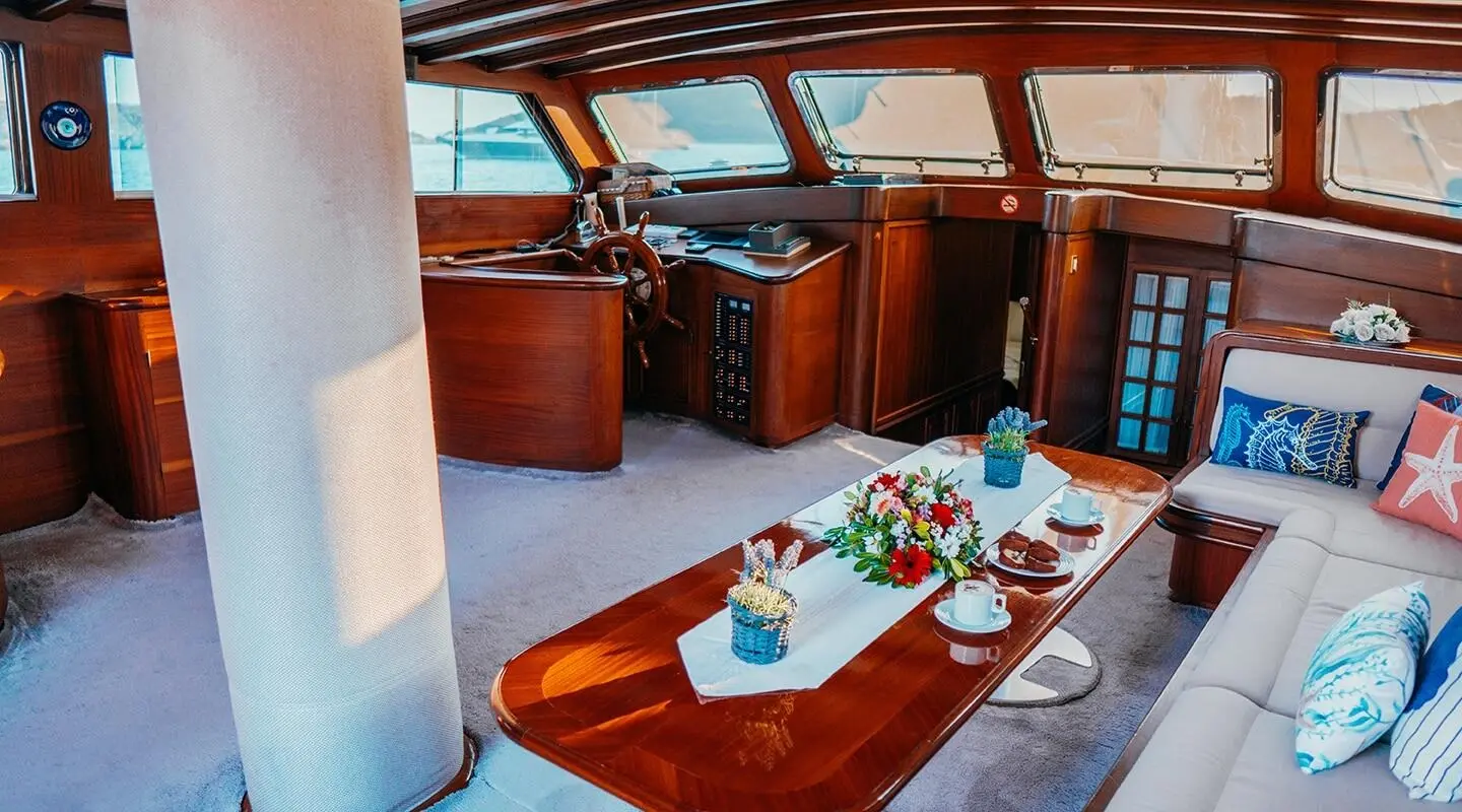 Wicked Felina yacht deck with teak table set for dining under a canopy at sunset