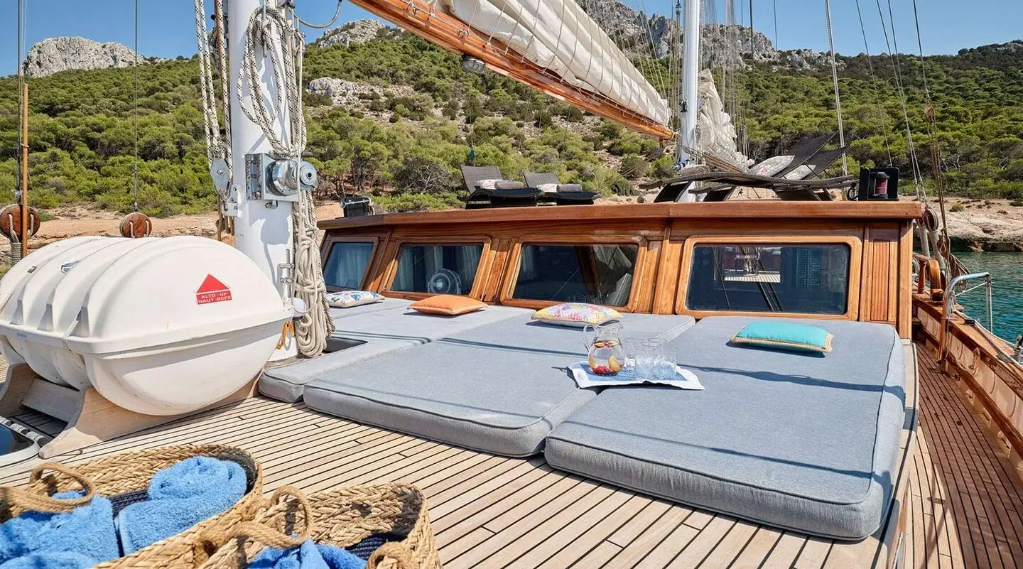 Gulet Myra sun loungers on deck, cushioned seating and blue sea view