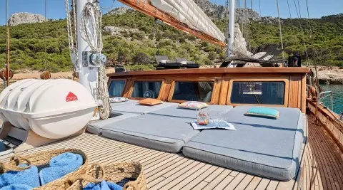 Gulet Myra sun loungers on deck, cushioned seating and blue sea view