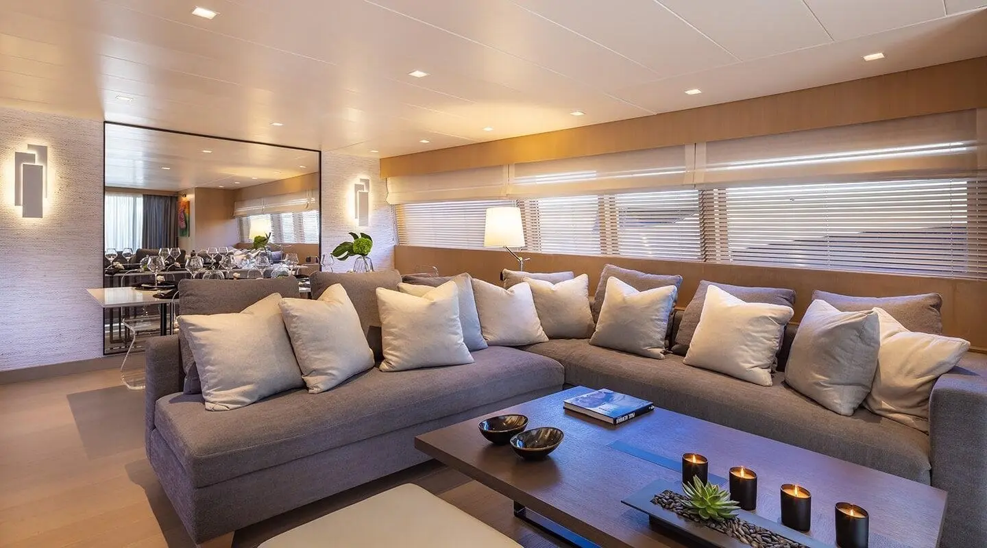Luxurious yacht interior salon with beige sectional sofa and wooden panels