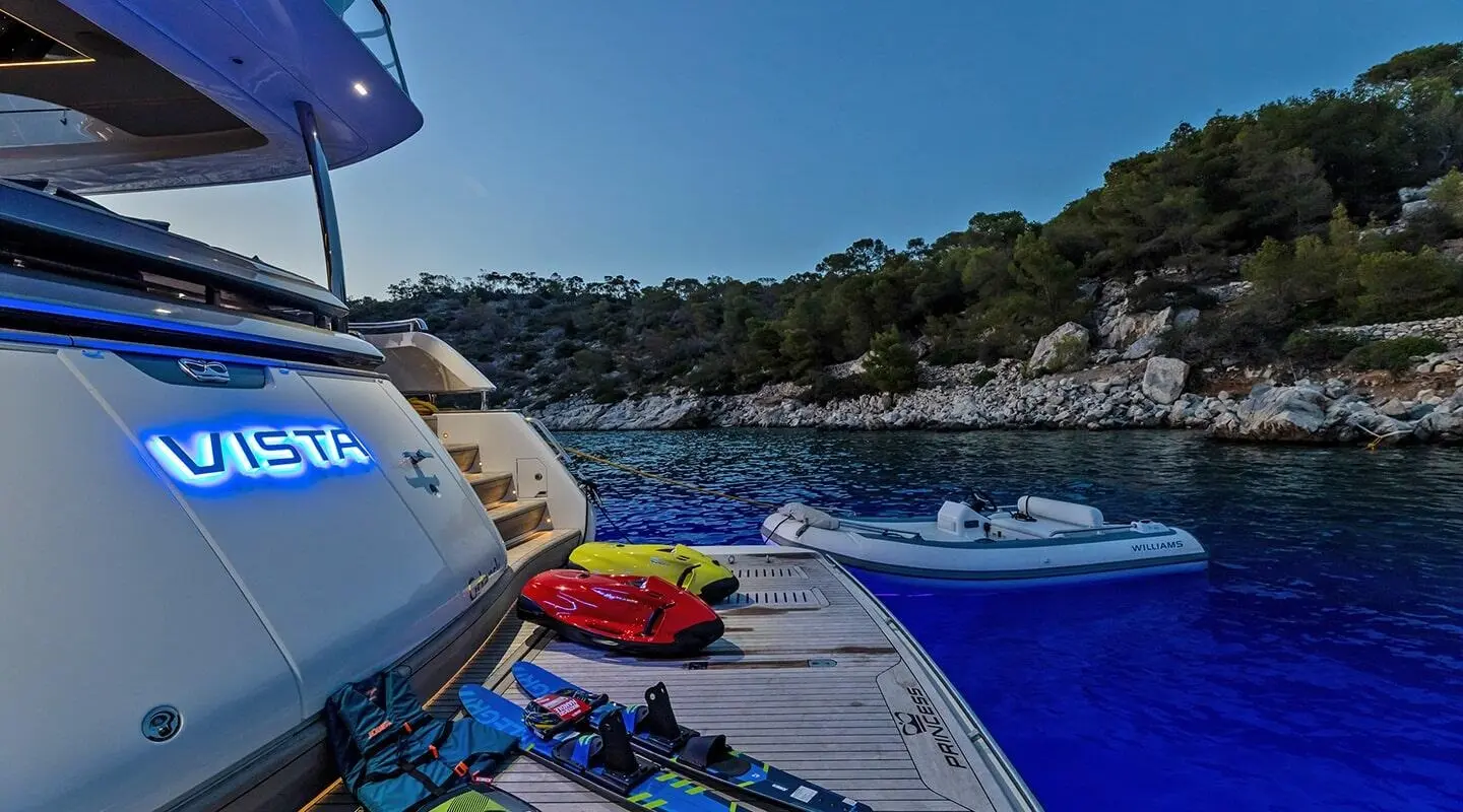 Vista yacht stern deck at dusk with blue glow and inflatable boat nearby