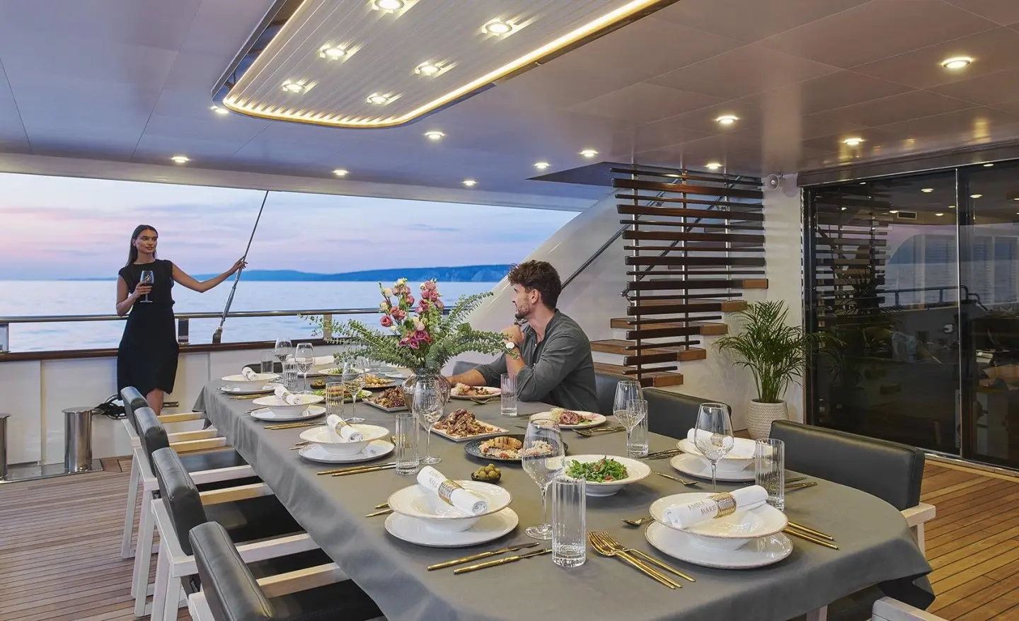 Dining area on aft deck of Motoryat Anima Maris with guests and sea view