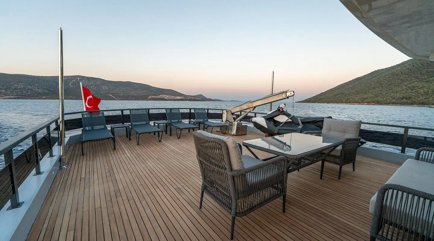Calm Down yacht aft deck with dining table and chairs overlooking water