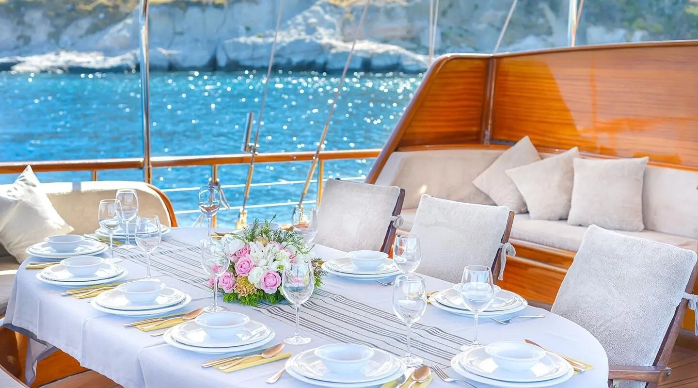 Lady Christa yacht dining table set for guests on deck with ocean view