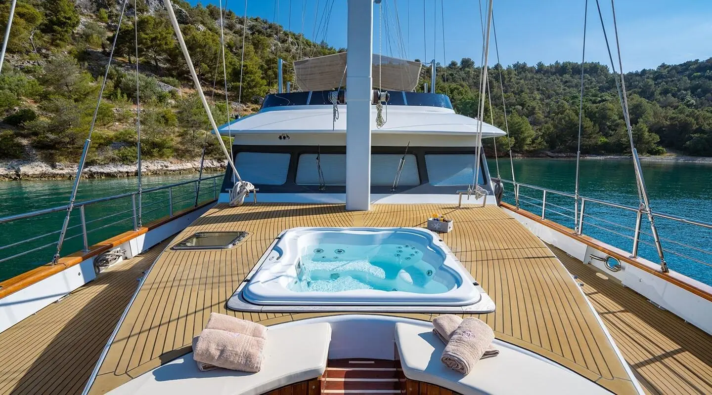 On the yacht Navilux's deck with a jacuzzi and seating area overlooking the water