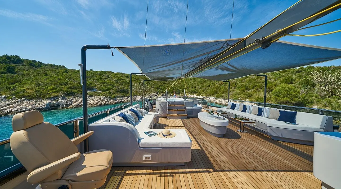 Gulet Rara Avis sun deck with cushioned seating and shade sail
