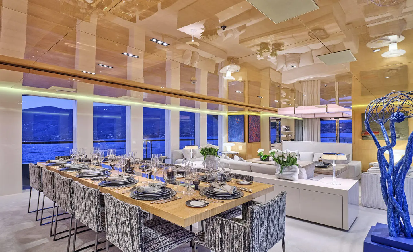 La Pellegrina 1 yacht dining deck with long table set for guests and warm lighting