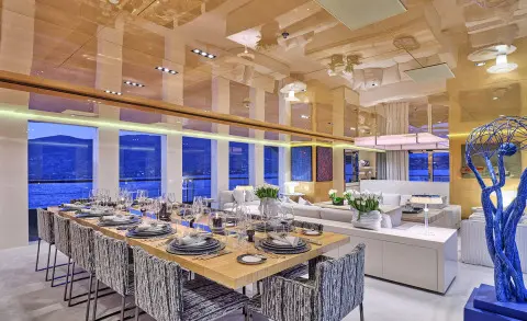 La Pellegrina 1 yacht dining deck with long table set for guests and warm lighting