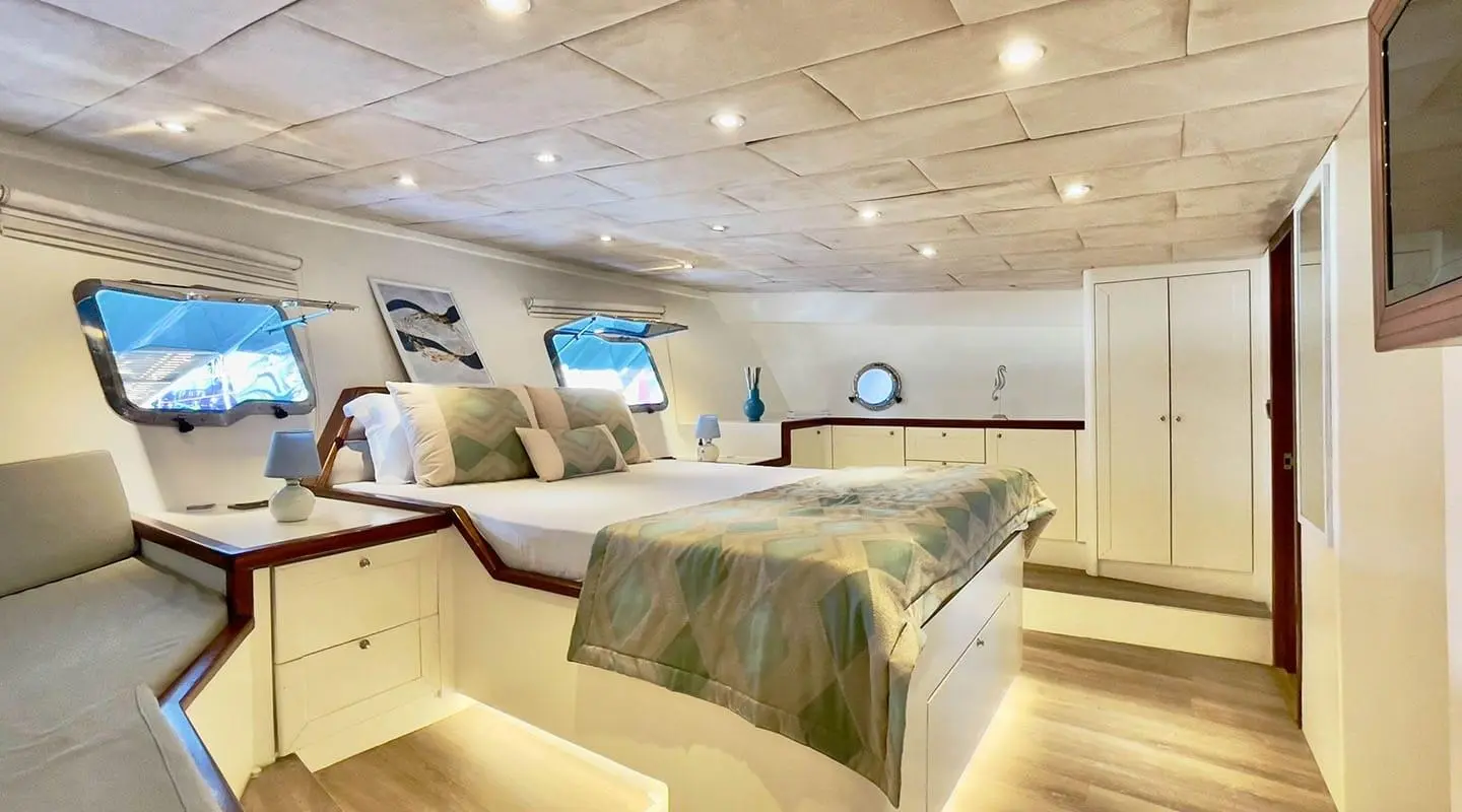 Derya Deniz yacht interior with bed, warm lighting, ceiling lights, and decor