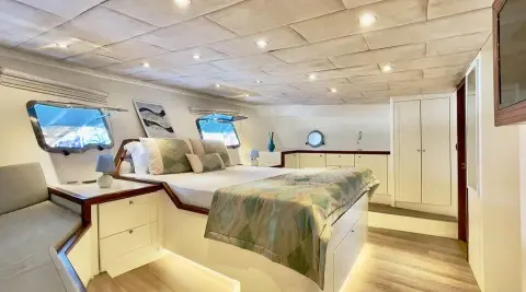 Derya Deniz yacht interior with bed, warm lighting, ceiling lights, and decor