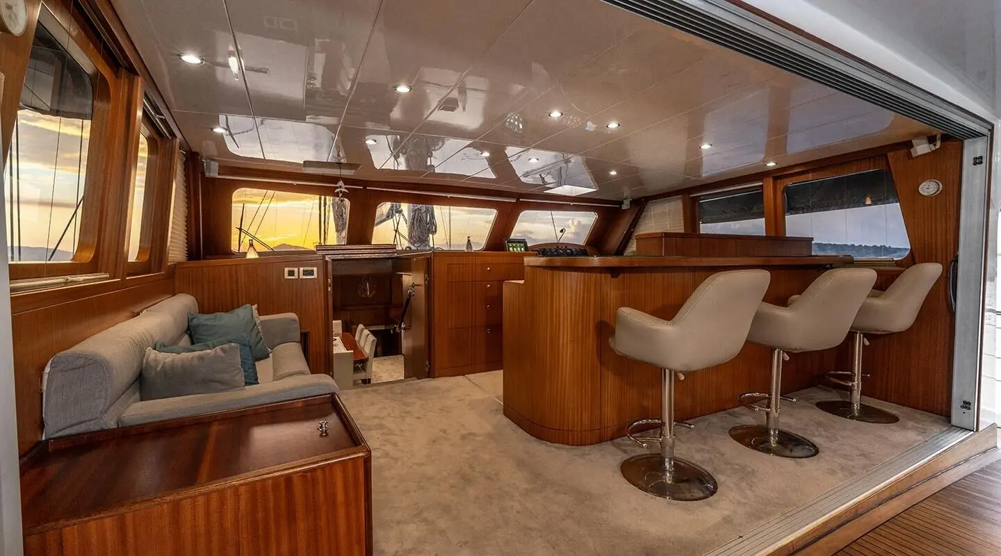 Interior of Lucky You yacht, wooden furniture, seating area, warm lighting