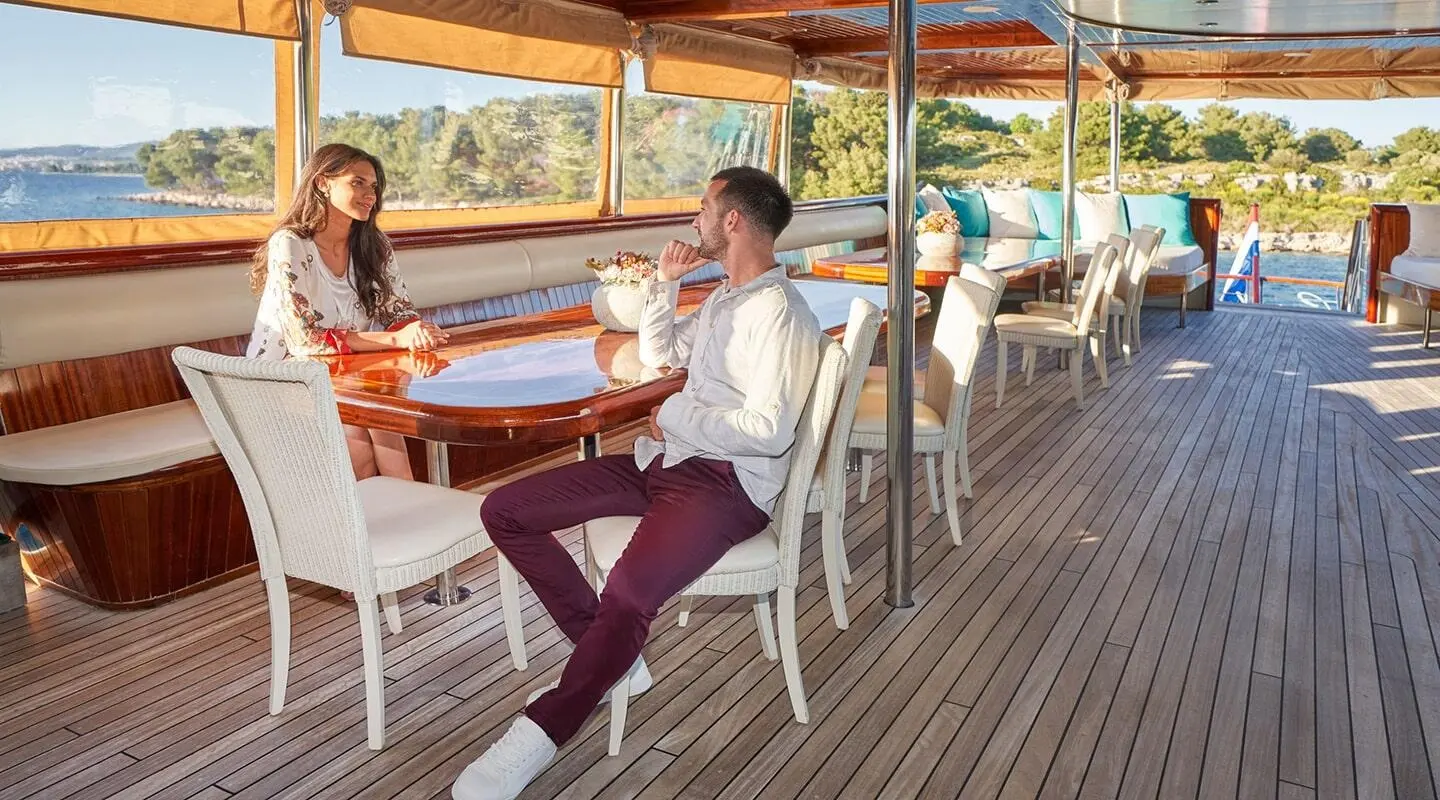 Casablanca yacht deck with passengers seated at table under shaded canopy