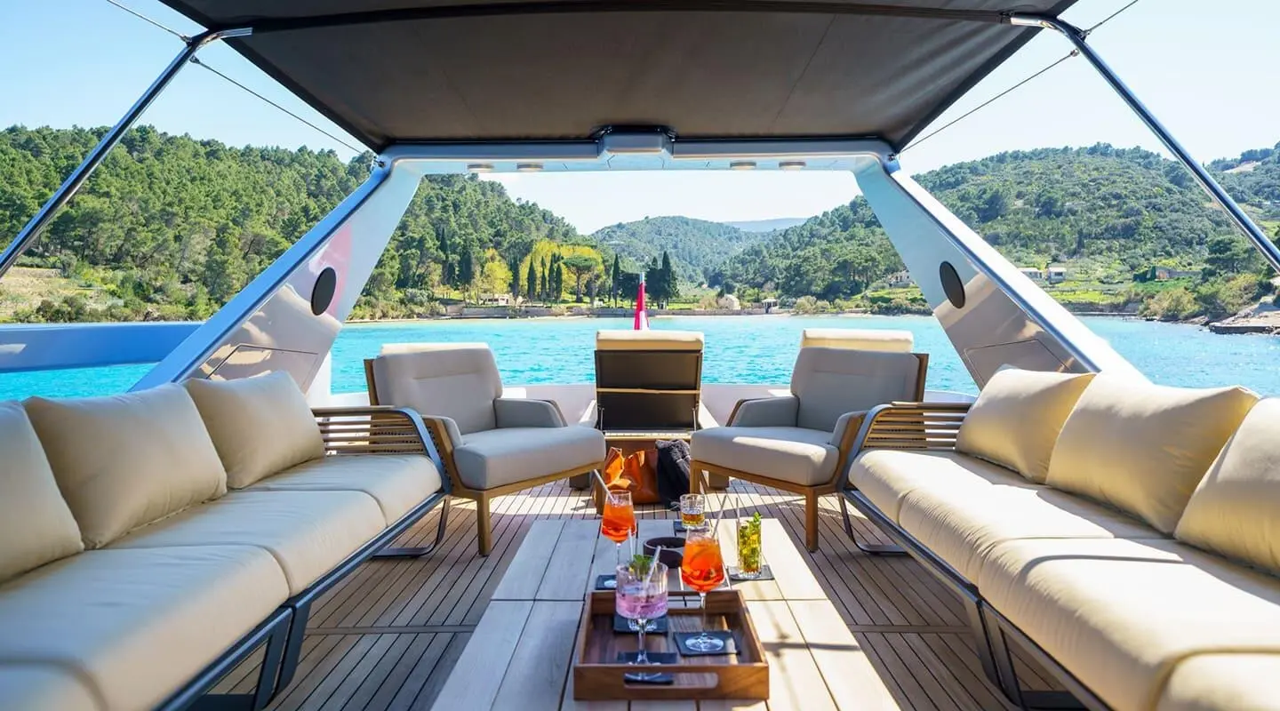Phantom yacht on calm sea with a shaded cockpit seating area and sunset view