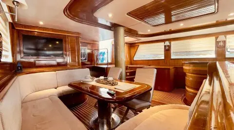 Diva Deniz yacht dining area with wood table, cushioned seating, and ambient lighting