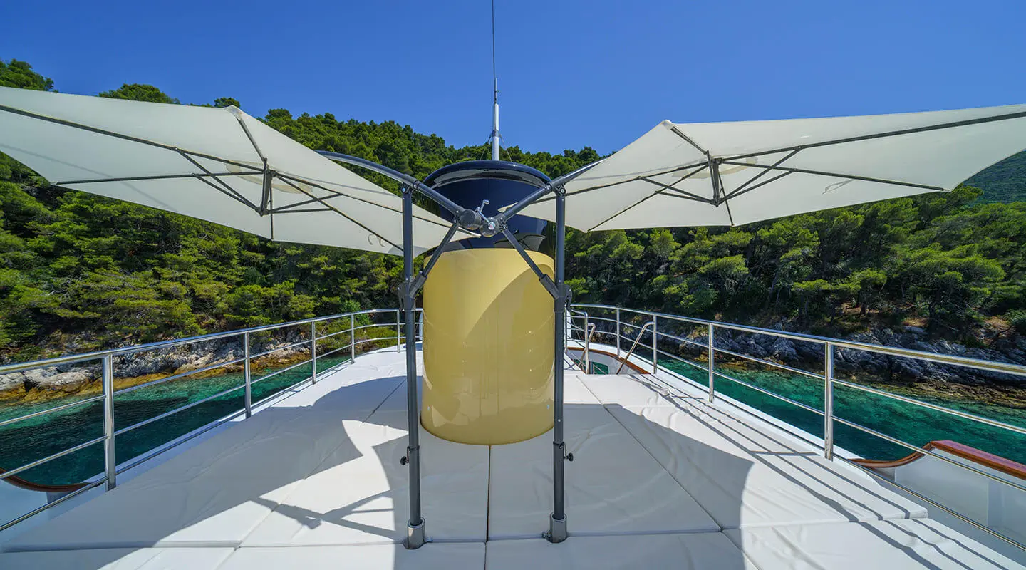 Maia yacht deck at sunset with shaded seating area and railing