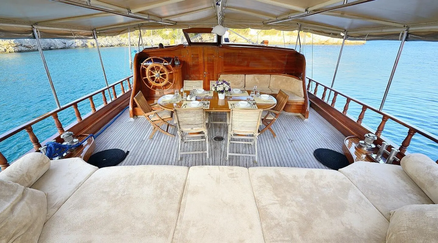 Samarkand yacht deck shown with seating area, teak wood, and sunset glow