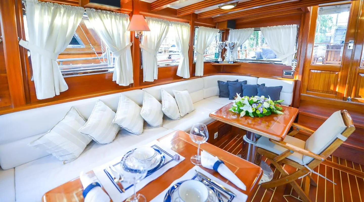 Ros Mare yacht charters: sunset view from deck with white cushioned seating and blue accents