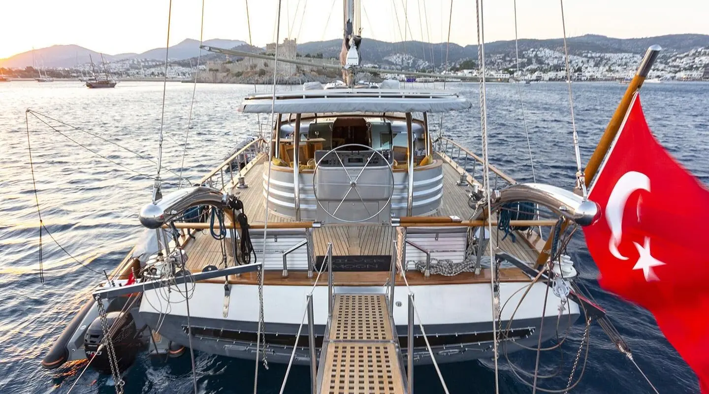 Silver Moon yacht deck cockpit with wooden railing and calm sea at sunset