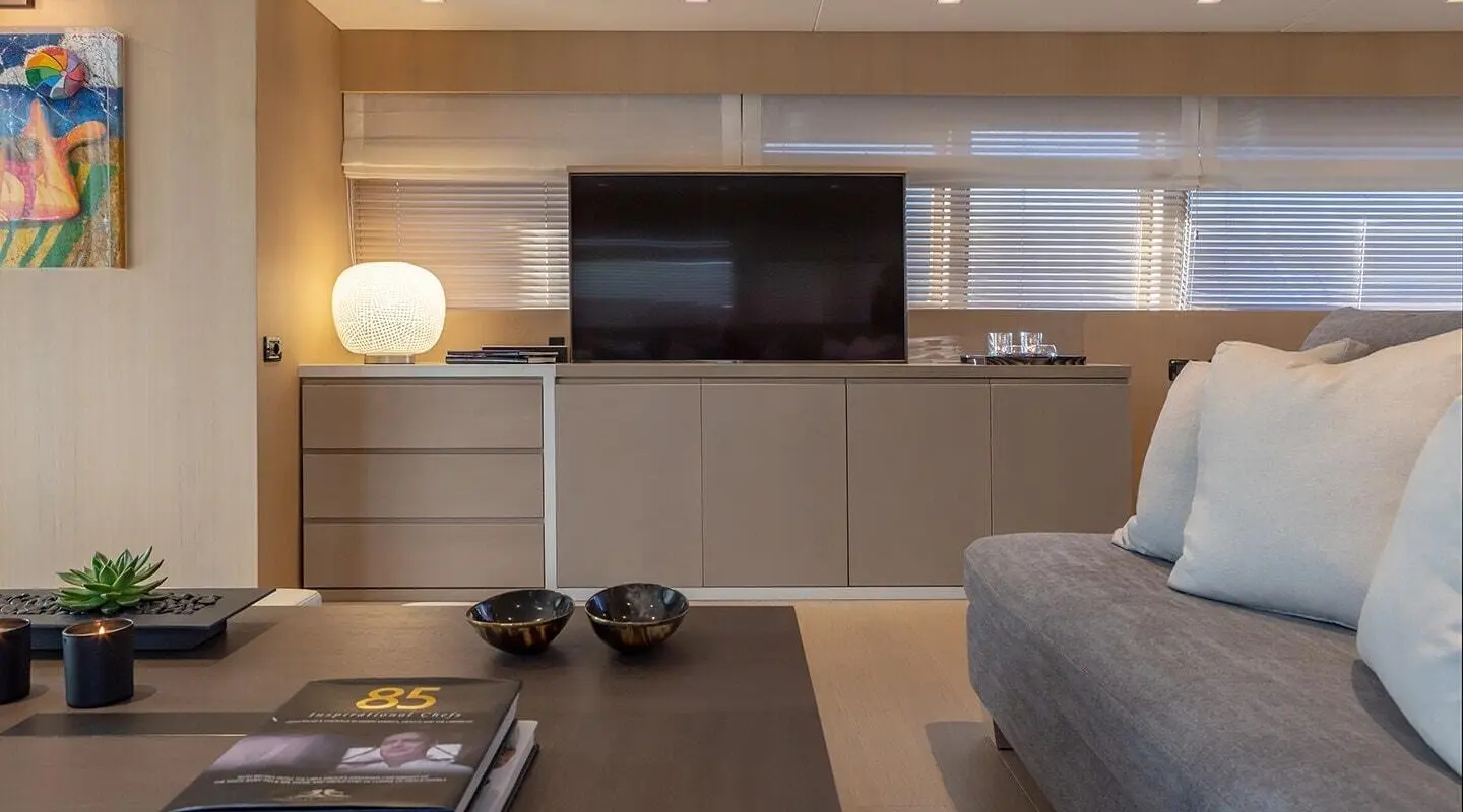 Interior view of the yacht's bright salon with seating, coffee table and TV