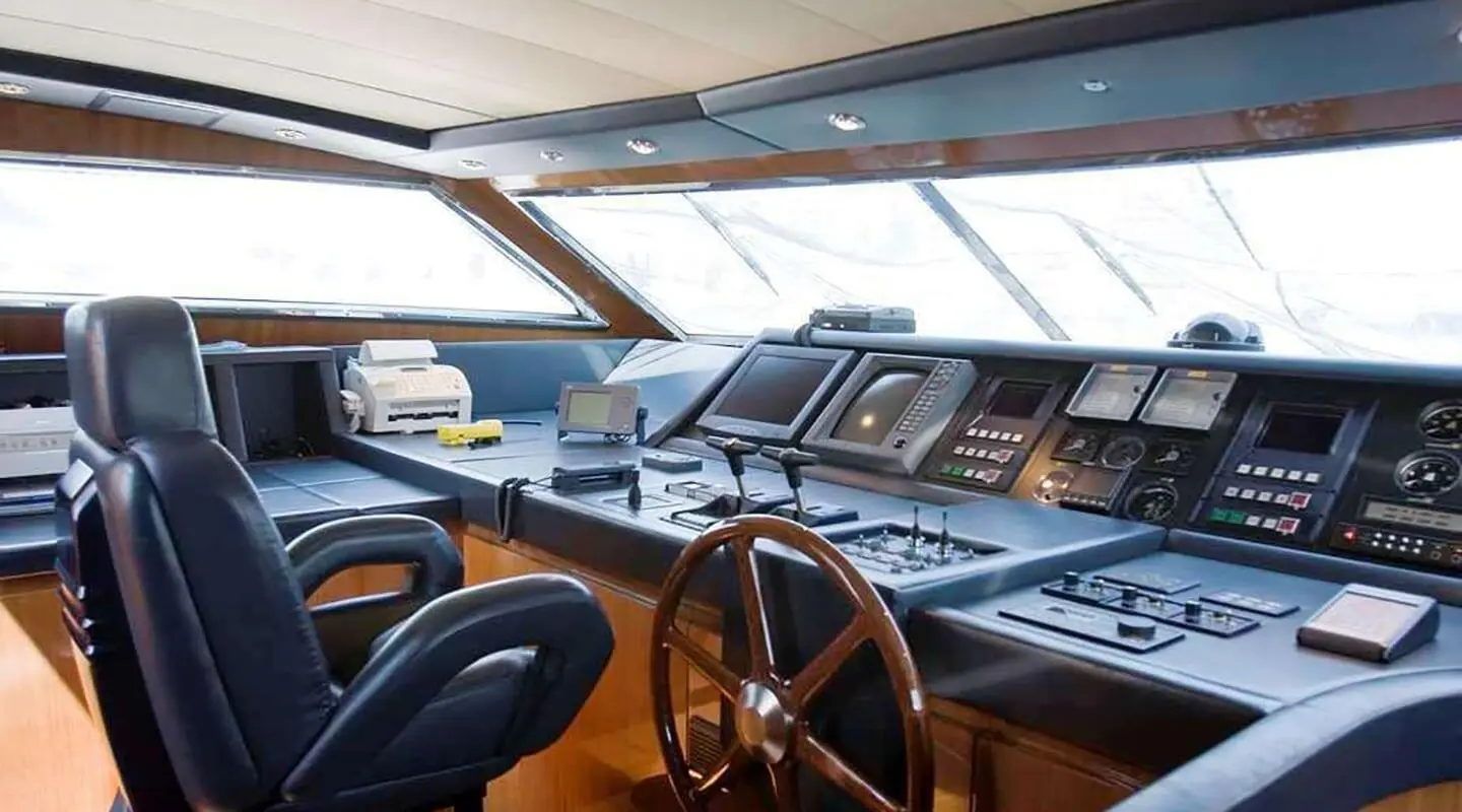 Interior yacht helm with steering wheel, navigation screens, and seating aboard Grace