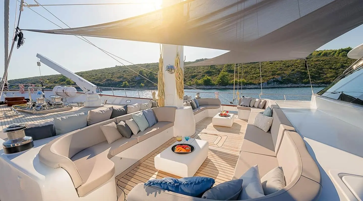Lady Gita yacht alfresco lounging area with cream upholstery and sea view