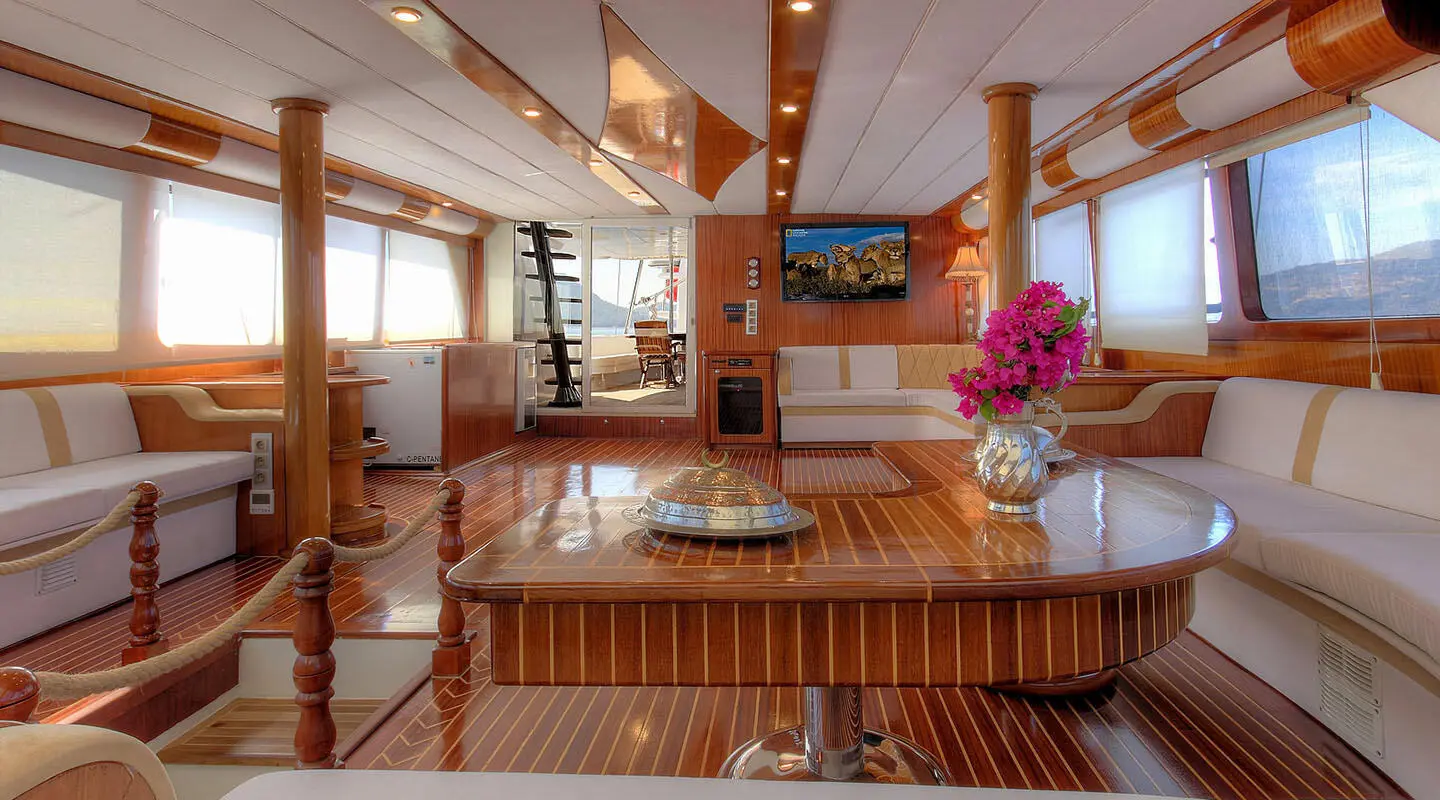 Angelo II yacht interior with wooden dining area and open deck windows