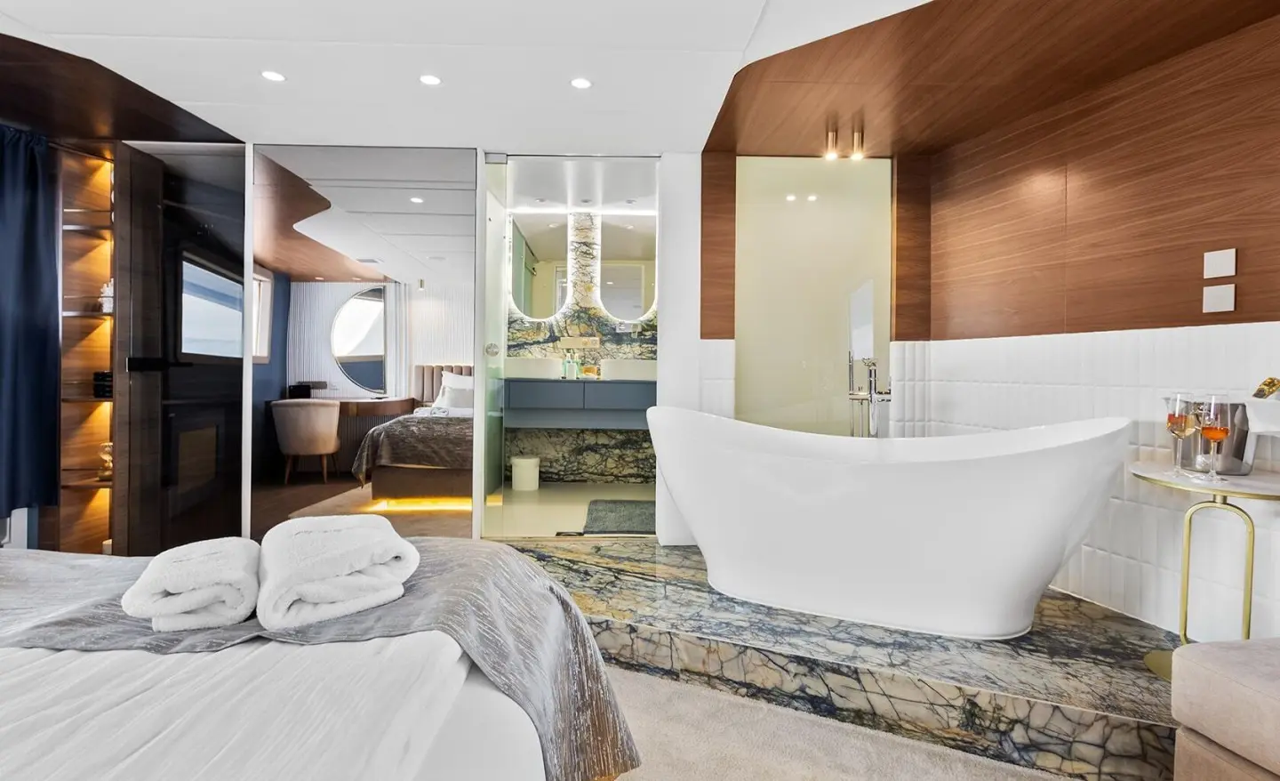 Interior with a large freestanding bathtub, wood walls and a modern bedroom