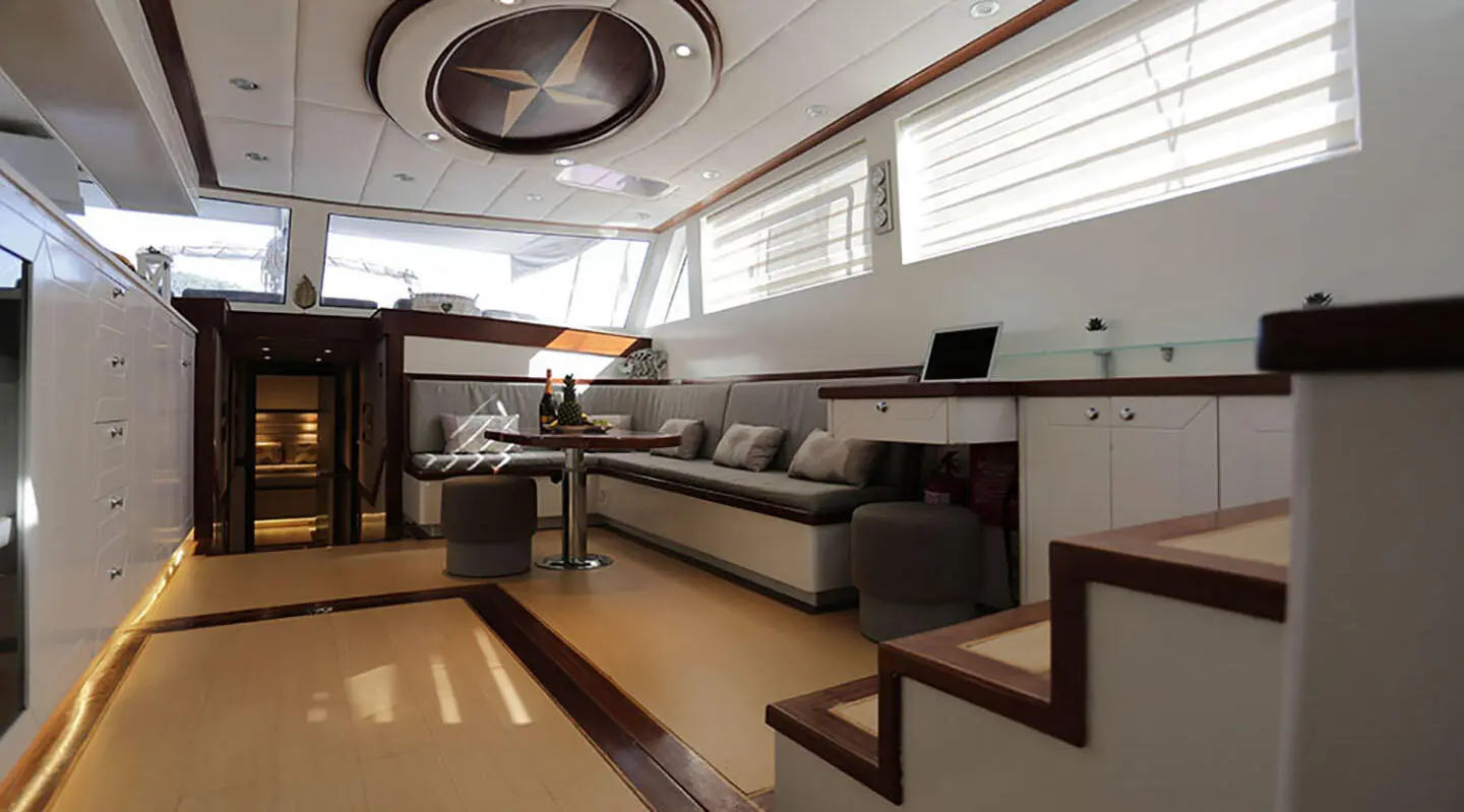 Interior of yacht lounge with seating, table and white cabinets