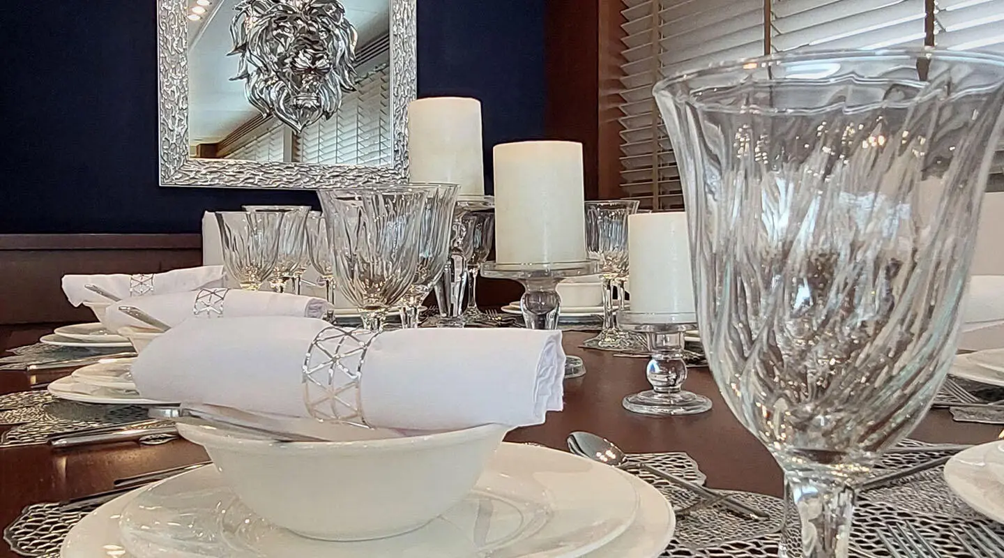 Miraval yacht dining table set for sunset, crystal glasses and plates