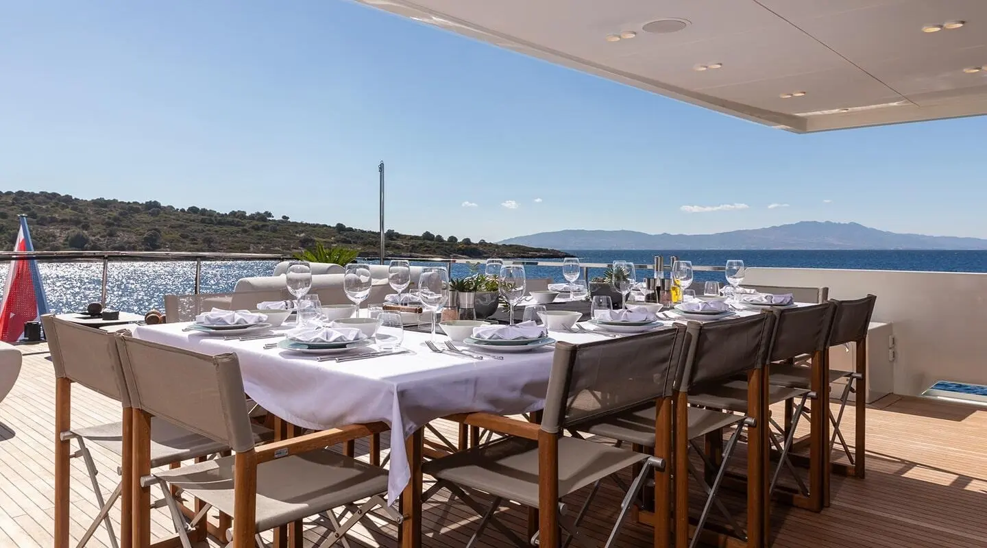 Illusion II yacht table setting on a balcony with chairs and harbor view