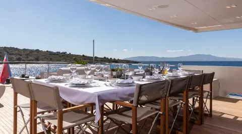Illusion II yacht table setting on a balcony with chairs and harbor view