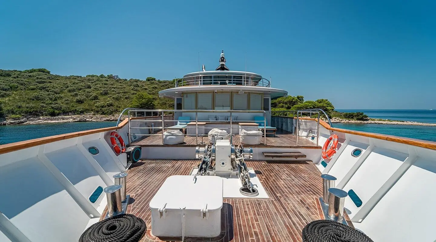 Riva yacht deck at sunset with lounge chairs and sun loungers on wooden deck