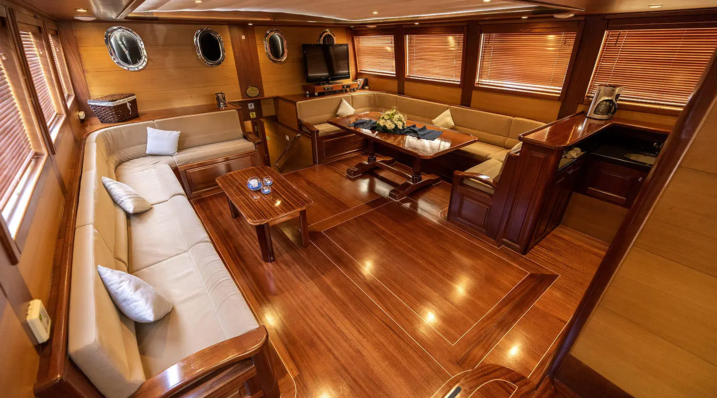 Kayhan 4 yacht interior: polished wood dining area with table and seating